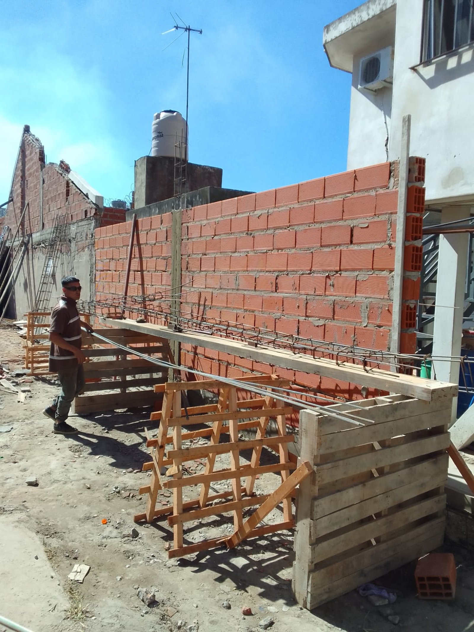 obra de pared de ladrillos con andamios de madera — proyecto Deposito en Avellaneda 2, por Arquitecto Guido Niccoli, en B1872 Sarandí